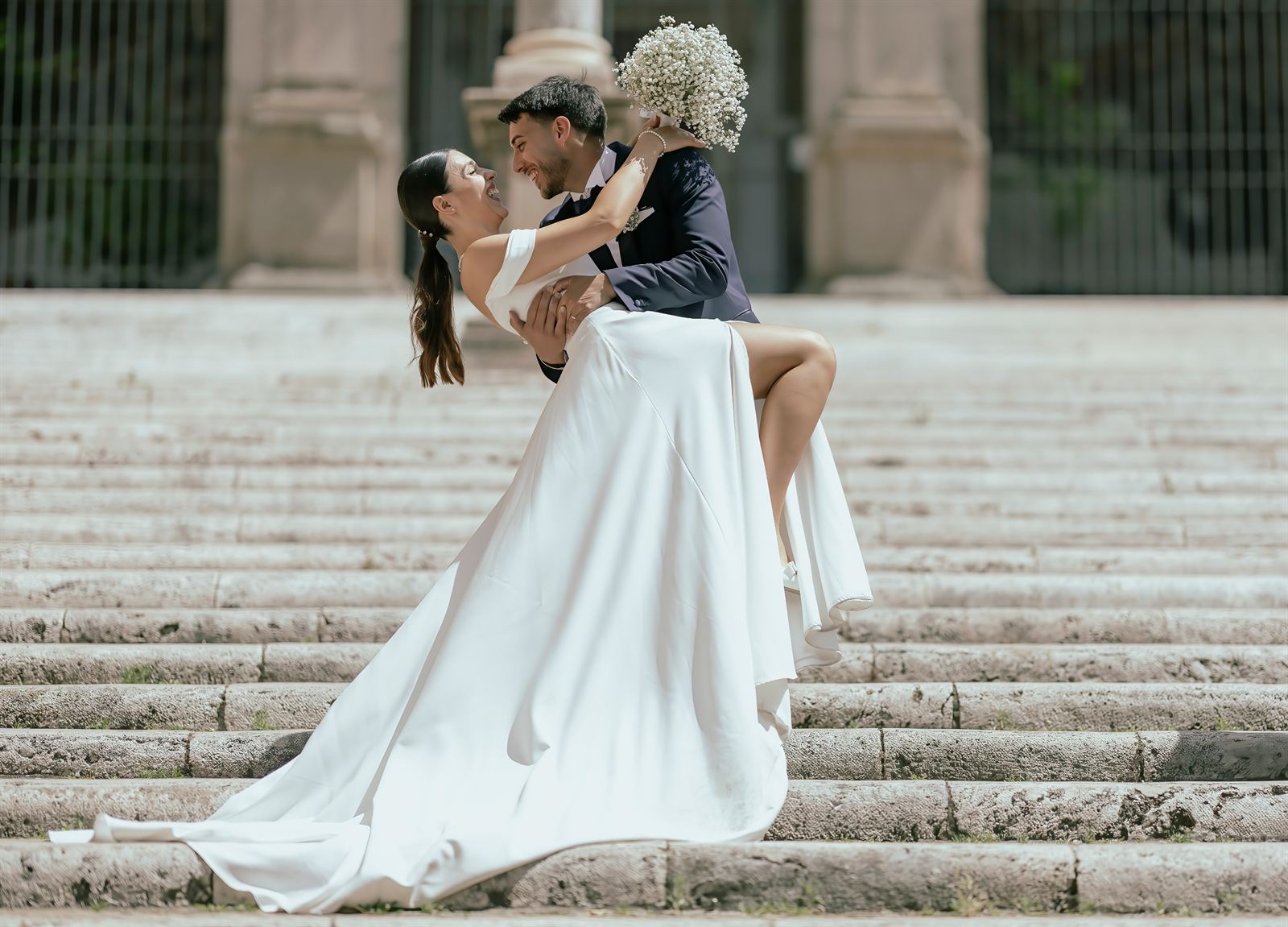 Lo sposo solleva la sposa su una scalinata di Roma