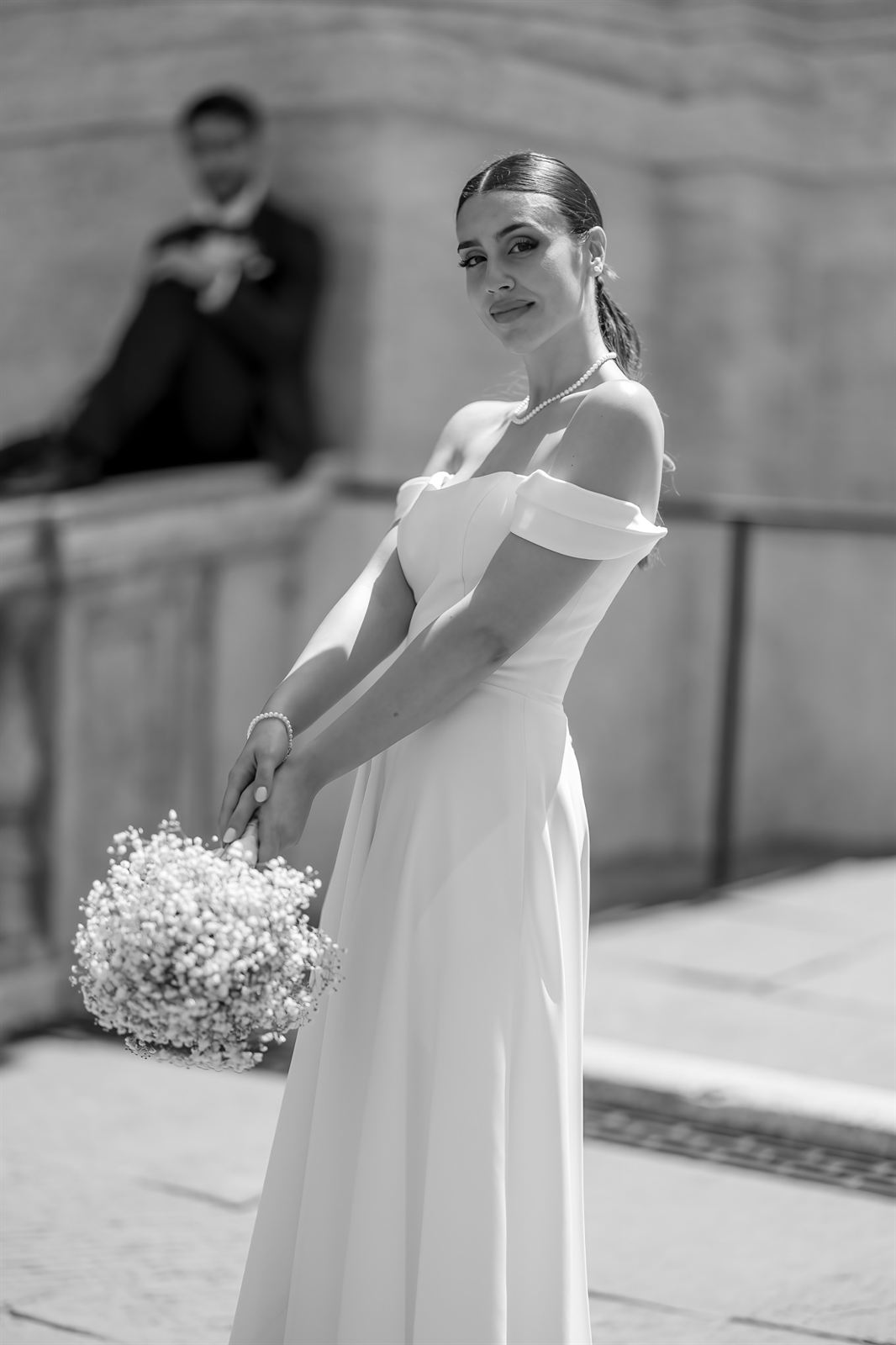 Ritratto della sposa con lo sposo sullo sfondo, in bianco e nero