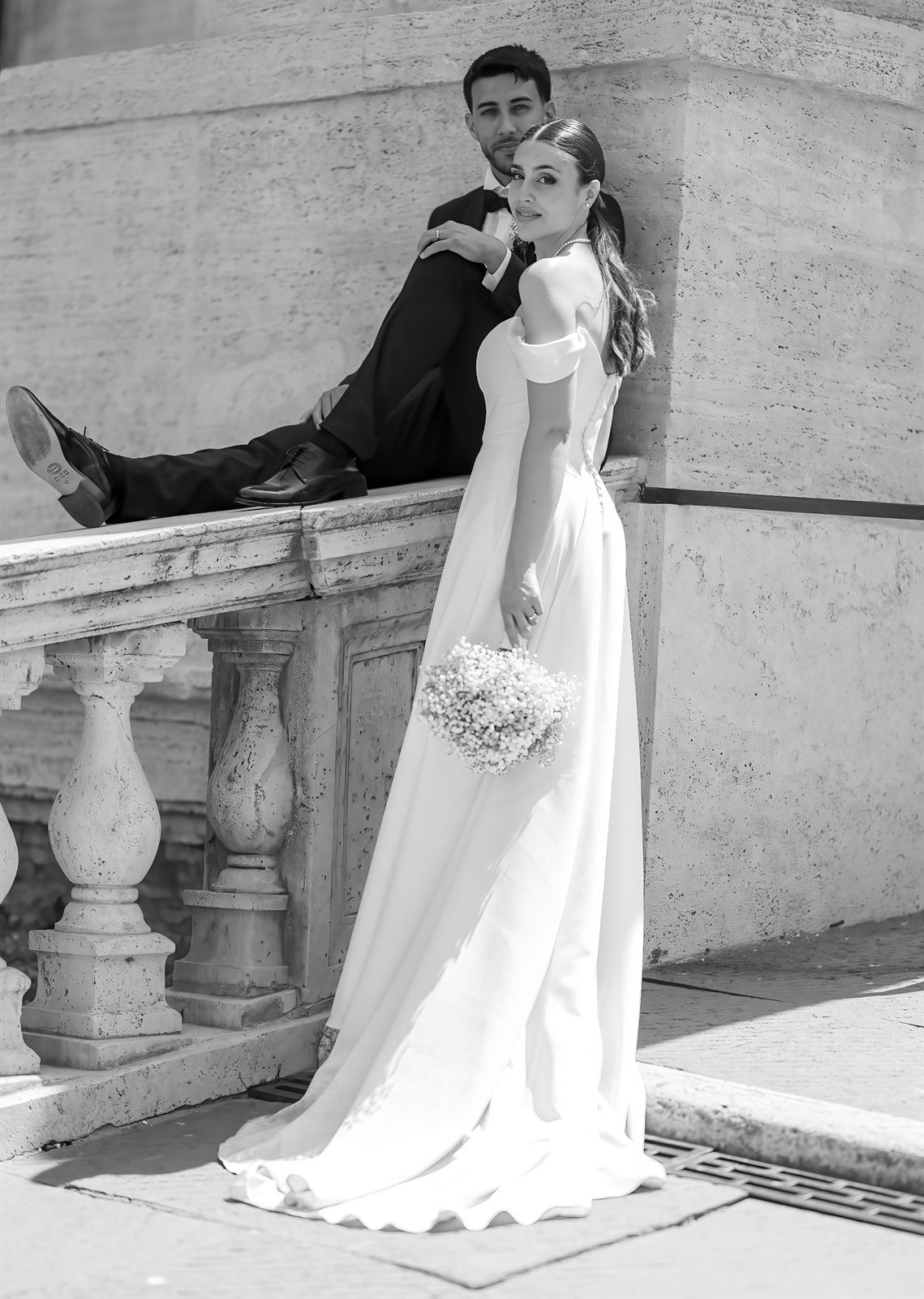 Sposi appoggiati a una balaustra in travertino, in bianco e nero
