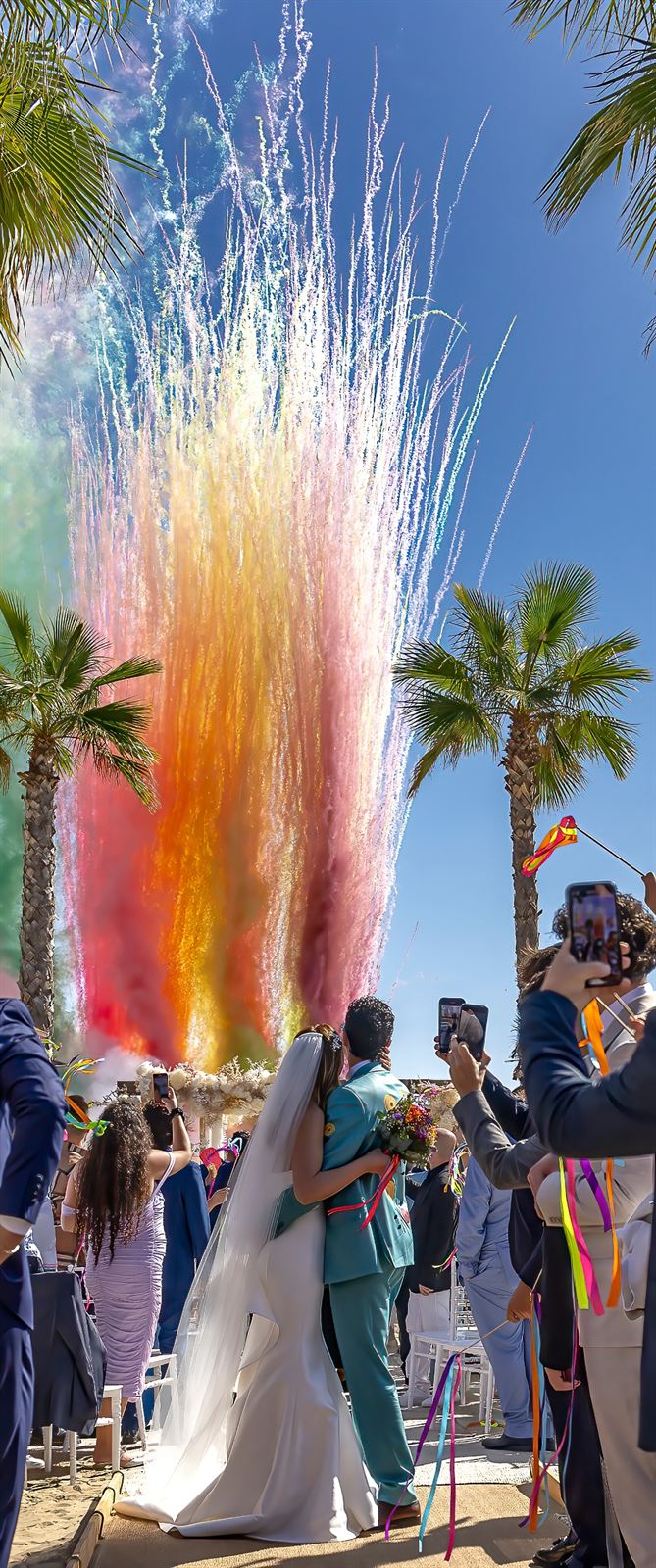 Uscita degli sposi tra fumogeni colorati e la festa degli invitati